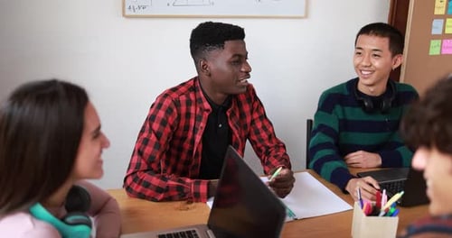 Multiracial Students Reading Books and Using Laptop While Studying Together - School
