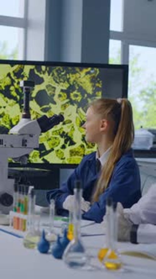 Women Working in Laboratory with Microscope and Beakers