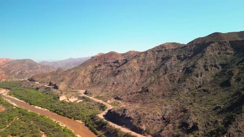Aerial view drone flying over scenic rocky mountains and a red river landscape