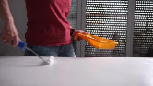 Woman Painting Table with Roller and White Paint