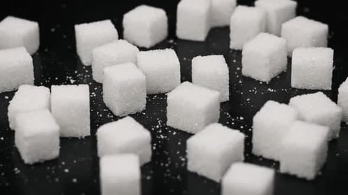 Zuckerwürfel drehen sich auf dem Tisch CloseUp