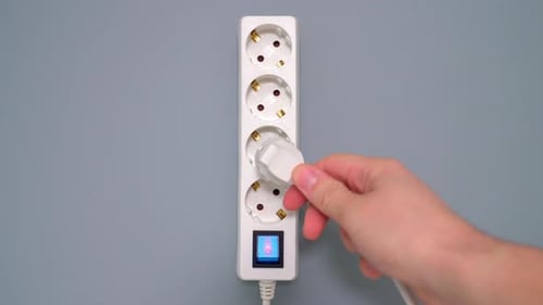 Weiße elektrische Steckerverlängerung mit grauem Hintergrund