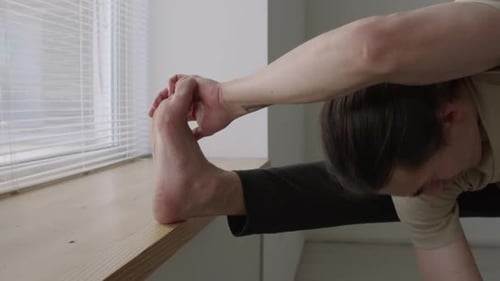 Male Dancer Stretching Muscles before Rehearsal in Studio
