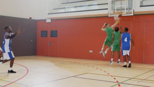 Défenseur de clôture de la ligne de fond, duo masculin afro-américain dribble, passe, saute pour un lay-up au gymnase