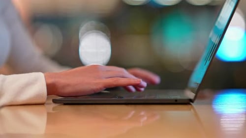 Die Hand einer Frau, die auf der Laptoptastatur tippt — Detail der digitalen Arbeit