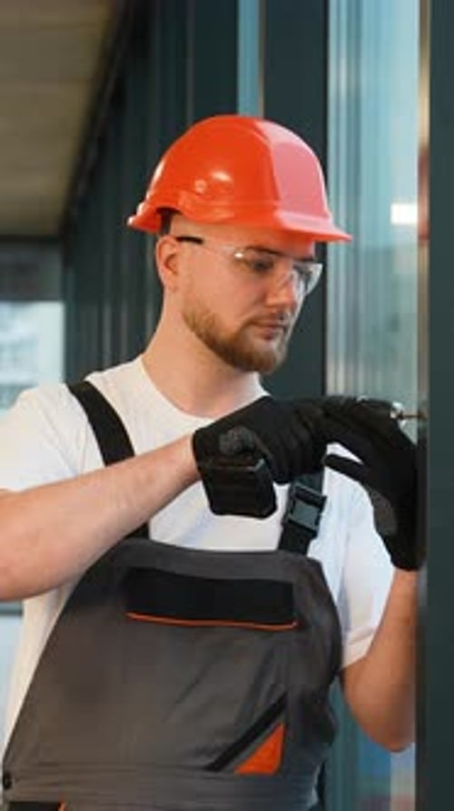 Construction Worker Using Cordless Drill on Site