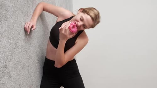 Young Woman Eating Donut After a Workout