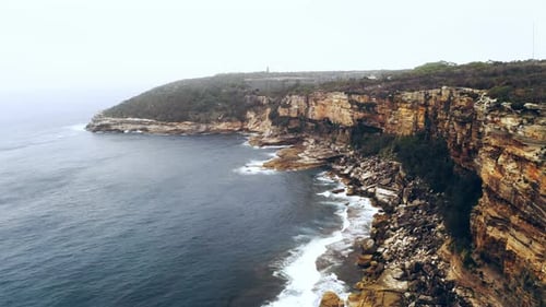 Sea waves crashing against a rocky coastline during the day