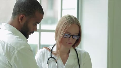 Woman Doctor Discusses Tablet With Man in Hospital