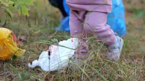 Kleines Mädchen sammelt Müll auf und hilft so, die Umwelt zu schonen