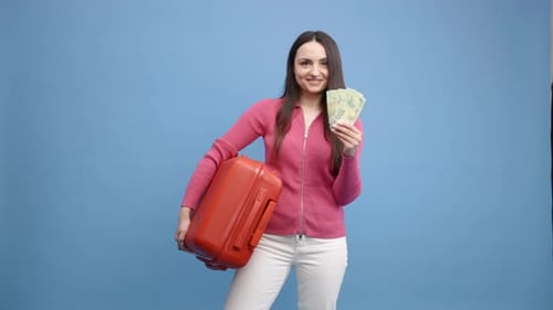 Smiling Woman Holding Money and Small Orange Suitcase
