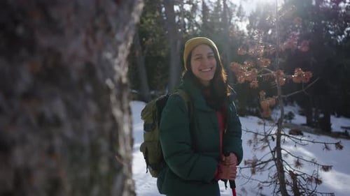 Hiker Smiling and Hiking in Snowy Forest Trail During Winter Day
