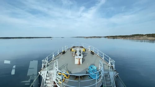 Tug boat travelling across narrow Finnish archipelago fairway during summer day. Calm seas and blue