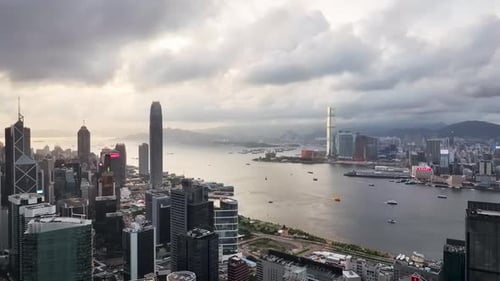Luftaufnahme der geschäftigen Wolkenkratzer und des Hafens bei Sonnenuntergang, Hongkong.