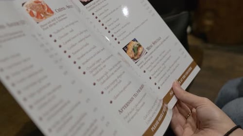 Girl looking at close up of menu in vintage coffee shop as lockdown rules relax
