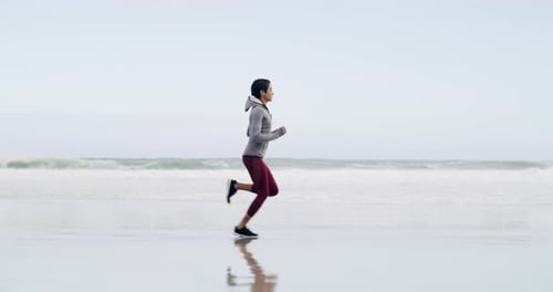 An attractive young sportswoman running on the beach