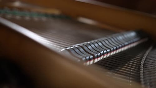 View inside a beautiful brown Grand Piano, hammers and strings moving as pianist plays classical mus
