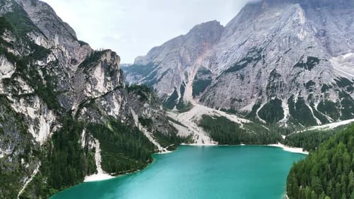 Drohnenaufnahme des türkisfarbenen Wassers des Pragser Wildsees, umgeben von dichtem Alpenwald und