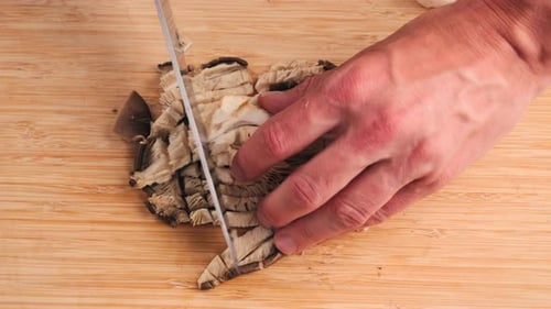 Fresh Royal Oyster Mushrooms Chef Cooking on a Wooden Cutting Board with Knife in Cafe Asian