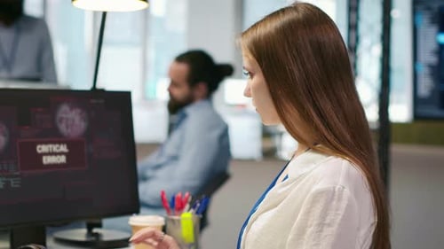 Female Engineer in Startup Office Struggling to Fix Critical Error Warning Popup