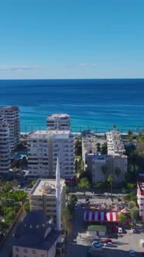 Vídeo vertical: vista aérea de la ciudad de Alanya con edificios muy compactos que combinan nuevos rascacielos y