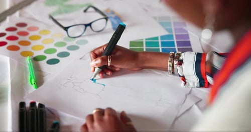 Fashion Designer Drawing a Sketch of a Dress