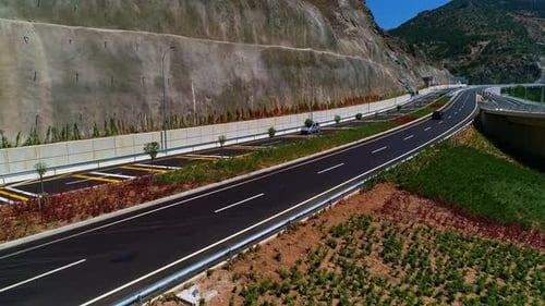 Luftaufnahme einer neu gebauten modernen Autobahn entlang eines Berghangs