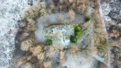 Scenic aerial descend over ancient church remains with seats and green fir tree