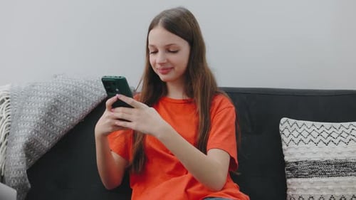 Teen with Smartphone Sitting on Sofa