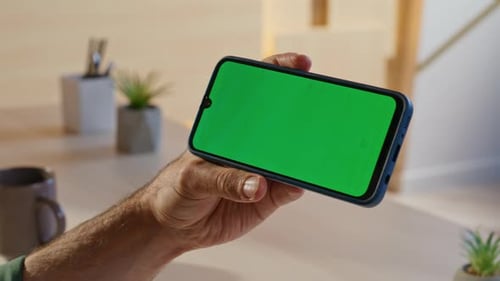 Office Professional Swiping Chroma Key Smartphone in Modern Workplace Closeup