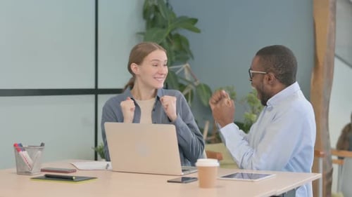 Two Colleagues Celebrate Work Success at Laptop