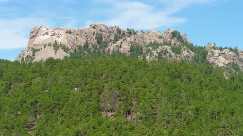 Mount rushmore presidents faces carved into granite cliffs slow motion aerial drone