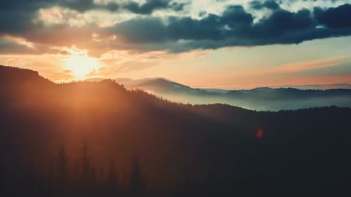 Majestic Mountain Range at Sunset with Rolling Clouds