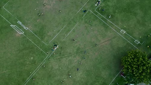 Aerial top down view of men training football on grass soccer field