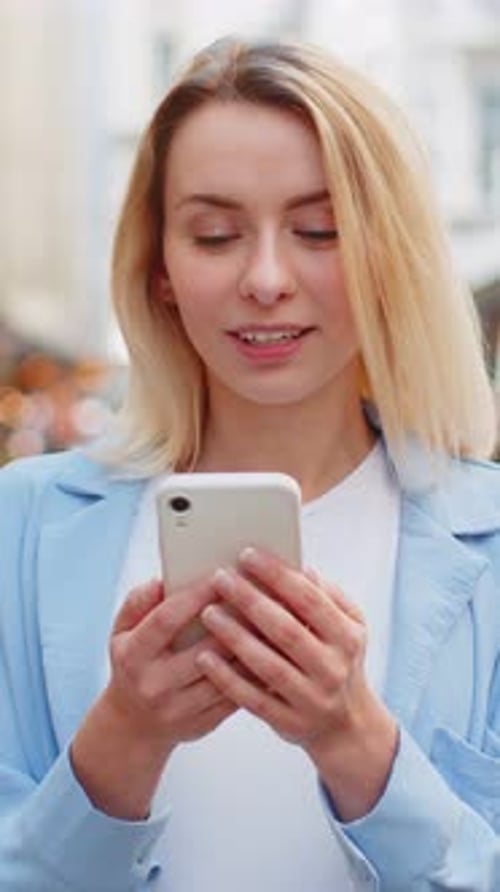 Smiling Woman Using Smartphone in City Environment