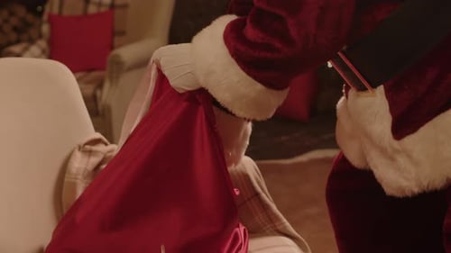 Santa Claus Prepares Presents in a Cozy Living Room