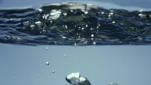 Bubbles Ascending in Clear Blue Water Close-Up
