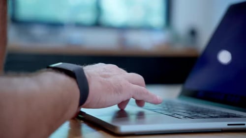 Side view of person working on laptop computer