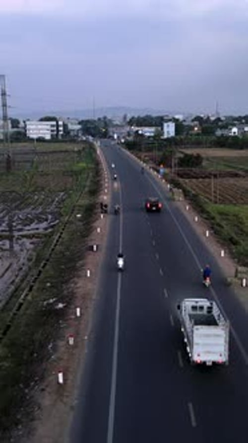 Drone Flying Over the Road Busy with Many Motorcycles Heading to the City in Vietnam