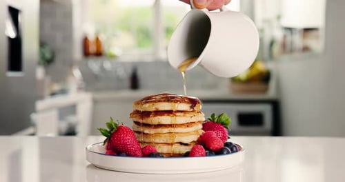 Maple syrup, breakfast and pancakes with hand in kitchen for strawberry, nutrition and health