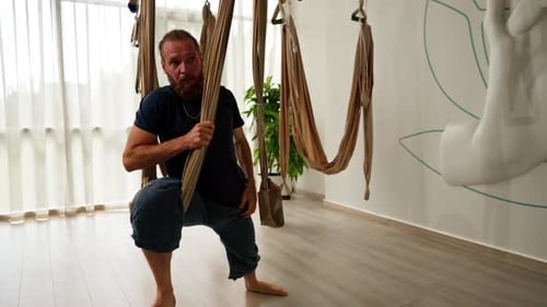 Man Doing Yoga in a Swing Indoors