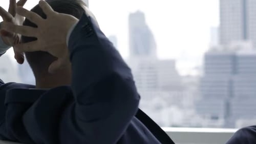 Businessman Stretching Arms, Relaxing And Admire View Sitting By Desk In Office