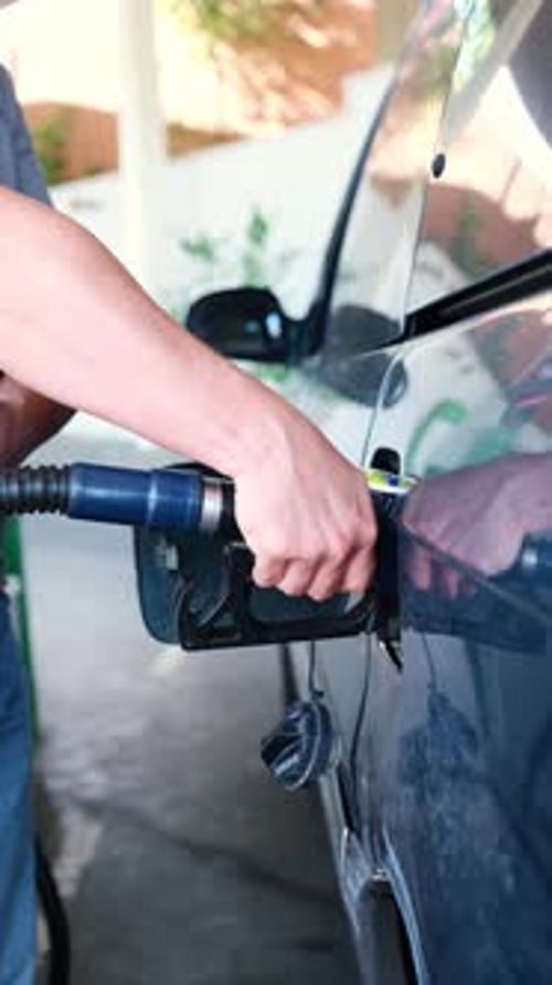 Man refueling his car at a gas station