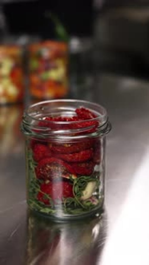 The chef preserves vegetables in the kitchen. Close-up