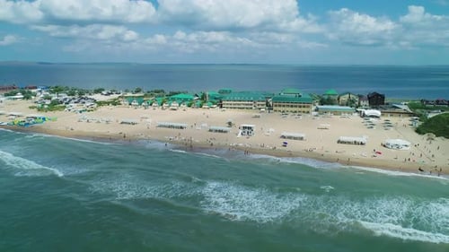 Aerial Over the Sandy Beach with Many People and Azure Water on a Summer Day Waves Crashing to the