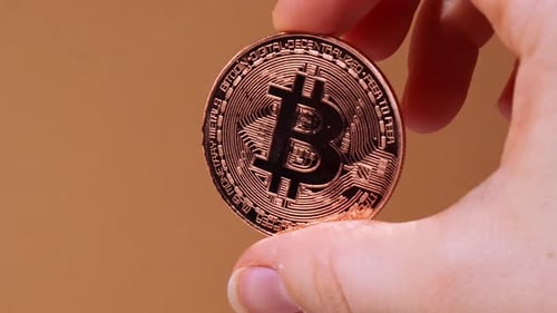 Hand Holding Gold Bitcoin Close Up