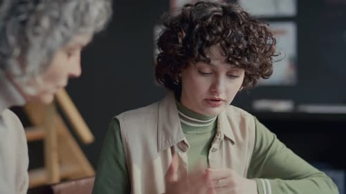 Jeune étudiante ayant une conversation avec un tuteur en cours d'anglais