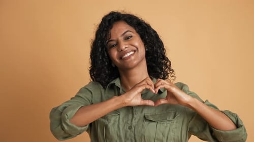 Woman Smiling and Making Heart Shape with Hands