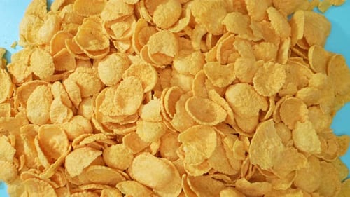 Delicious Yellow Corn Flakes on Blue Surface