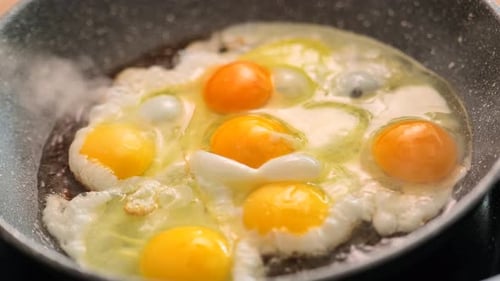 scrambled eggs.Eggs fall into the frying pan and fry with smoke.